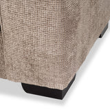 A beige textured fabric drapes over an unseen object, with a glimpse of a black base, against a white background.