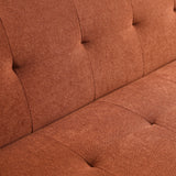 Close-up of a terracotta-colored upholstered sofa with button tufting detail, showing texture and stitching.