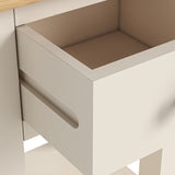 An open, empty drawer built into a beige table or cabinet, featuring a simple, elongated cut-out handle. The interior appears clean and unused.