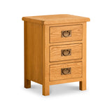 A wooden three-drawer bedside table with round metal handles, set against a white background.