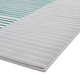 Gray-striped rug with alternating thick and thin lines on a white background, corner slightly lifted, revealing the rug's texture.