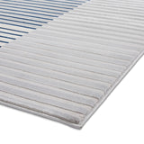 A grey and white striped rug rests flat on a white surface, depicting a clean, modern look.