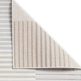 Striped fabric partially unrolled on a white surface, revealing its pattern and texture.