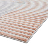 Striped rug with alternating beige and gray bands laid flat on a white surface, viewed at an angle.