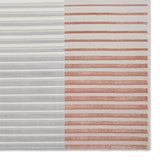 A rug with alternating horizontal grey and rust stripes, displayed against a plain backdrop.