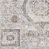 A textured fabric with an intricate pattern in shades of white, beige, and brown. It appears to be a close-up of a carpet or rug.