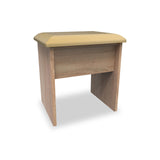 A simple wooden stool with a beige cushioned top, isolated against a white background.