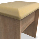 A wooden stool with a yellow cushion, stationary with detail on the fabric texture and wood grain.