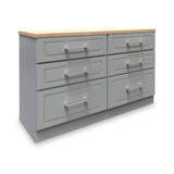 A grey wooden dresser with six drawers and silver handles, topped with a light wood surface, isolated on a white background.