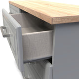 A partially open drawer under a wooden countertop, revealing a fabric-lined interior against a backdrop of gray cabinetry.