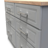 A gray cabinet with six drawers and metal handles on a wooden countertop, likely in a kitchen or workshop setting.