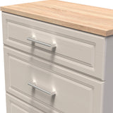 A beige wooden drawer unit with three closed drawers, each featuring a horizontal metal handle, against a white background.