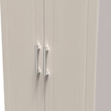 A closed double door with vertical handles stands still, set within a plain, unadorned wall. The color scheme is neutral.