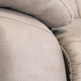 Close-up of a textured grey couch cushion with visible stitching, highlighting the fabric's detail and plushness.