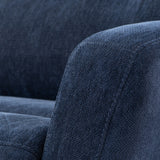 A close-up of a navy blue fabric sofa, with a detailed texture and stitching, set against a backdrop with a similar color and fabric.