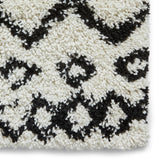 A close-up of a textured fabric with a black and white geometric pattern.