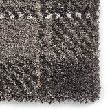 A close-up of a textured carpet with interwoven gray and white fibers, showcasing high pile density and a fluffy appearance.