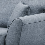 A close-up of a textured grey fabric sofa, showing a cushion and armrest, emphasizing comfort and minimalistic design. No text present.