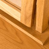 Wooden window frame and sill detail, showcasing joinery and wood grain, in bright natural light.