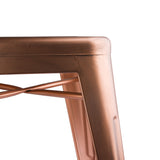 Copper-colored metal stool with intricate leg design, against a neutral background.