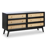 A black wooden dresser with six drawers featuring woven beige panels and small round knobs, set against a plain background.