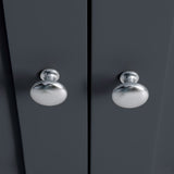 Two metallic doorknobs on a symmetrical dark grey surface, suggestive of a closed double door. The knobs reflect ambient light, centered in composition.