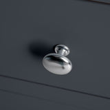 A metallic doorknob with a visible shadow is attached to a gray vertical surface.