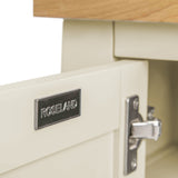 Metal label on a cream drawer reads "ROSELAND," partially open to reveal a metal sliding mechanism. It's set against a background of light-colored wood.