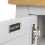 A metal nameplate on a white drawer reads "ROSELAND" with a wooden surface above and a drawer catch slightly visible.