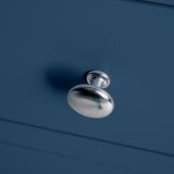 A metallic door handle protrudes from a blue surface, casting a shadow, creating a minimalist aesthetic.