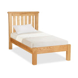 A single wooden bed with a white mattress and pillow, against a white background.