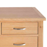 A wooden bedside table with two closed drawers featuring metal handles, set against a plain white background.