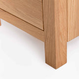 Corner of a wooden cabinet with a visible drawer, against a white background.