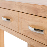 A close-up view of a wooden cabinet with two metal handles on its drawers, against a neutral background.