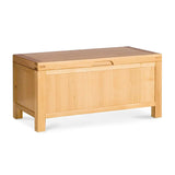 A wooden storage bench with a flat lid and a simple cutout handle, displayed against a white background, stationary.