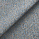 Blue textured fabric folded to create a shadow across the surface, presenting a close-up view of textile detail.