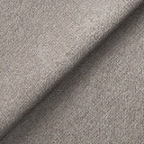 Textured fabric with a diagonal fold creating a shadow, showcasing a detailed weave pattern, likely a clothing material.