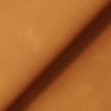 A smooth orange surface bisected diagonally by a shadow, suggesting a fold or edge, creating a visual contrast in lighting.