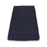 A dark blue, rectangular sleeping bag is lying flat with visible stitching, creating tufted sections. It appears smooth and unfurled, set against a white background.