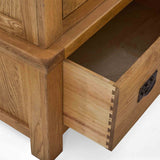 A wooden drawer is partially open, revealing dovetail joint construction, with no contents inside against a white background.