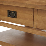 A wooden piece of furniture with a brass label holder on the drawer, set in a warmly lit environment.