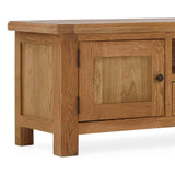 A wooden coffee table with a closed cabinet door, on a plain background, the door has a black handle.