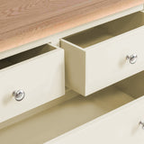 Open beige drawers with silver knobs, partially revealing an empty interior, in a tan-colored wooden cabinet structure.