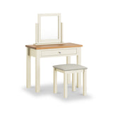 A wooden dressing table with a mirror and a matching stool on a white background. The table has a single drawer with a knob.