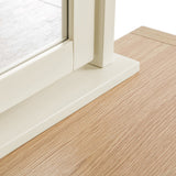 A sliding glass door's white frame and track rest on a wooden floor, depicting a detail of indoor-outdoor transition.