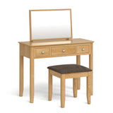 A wooden vanity table with a rectangular mirror stands with an accompanying padded stool, isolated on a white background. There are no texts in the image.