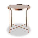 A round copper-colored metal side table with a reflective tabletop stands isolated against a white background.