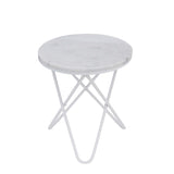 A round marble-top table with a white, crossed metal base stands idle against a white background.