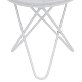 A white circular table with crossed metal legs stands against a solid neutral background, likely indicative of a product showcase or minimalist design.