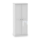 A white, freestanding wardrobe with closed double doors stands isolated against a plain, light background.